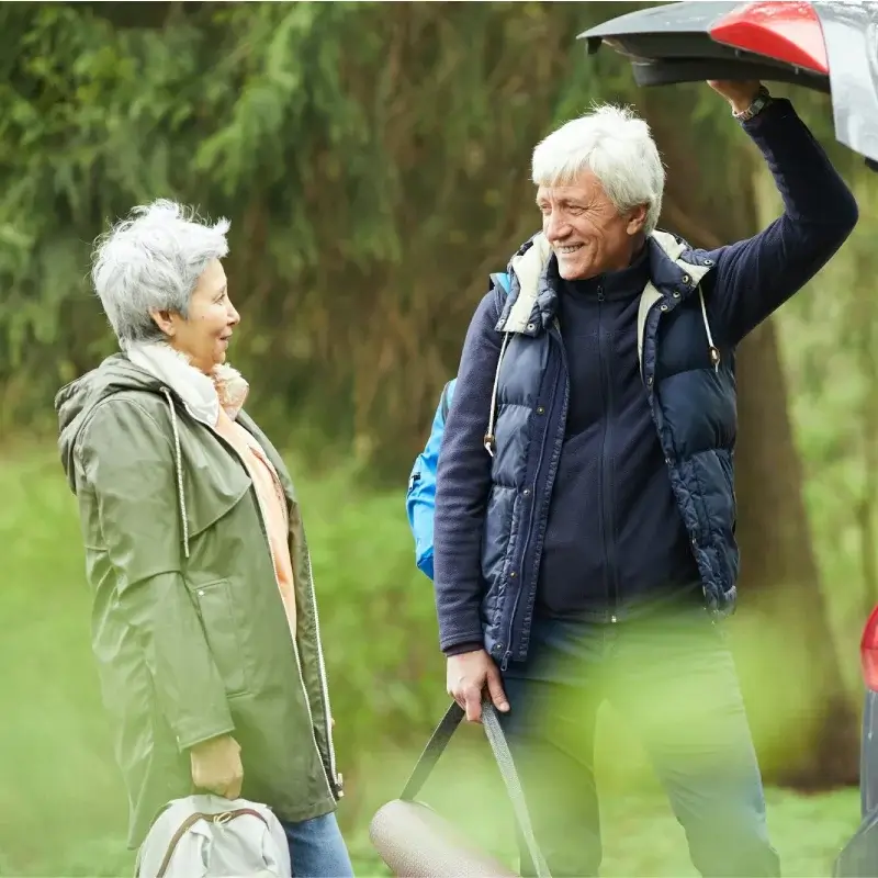 An active senior couple putting things in the trunk of the car
