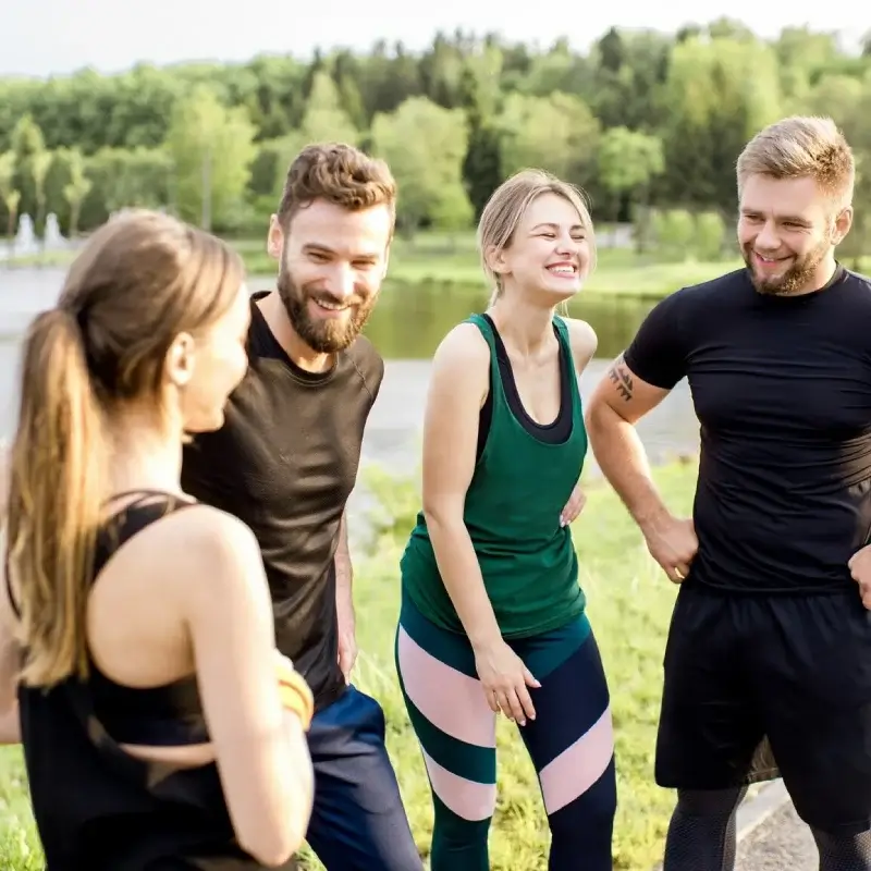 A group of athletes smiling in front of a lake